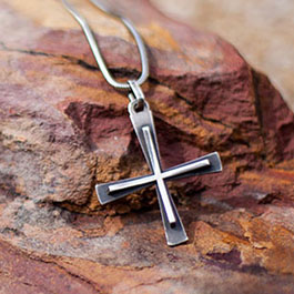 Kreuz an einer Kette auf einem Stein